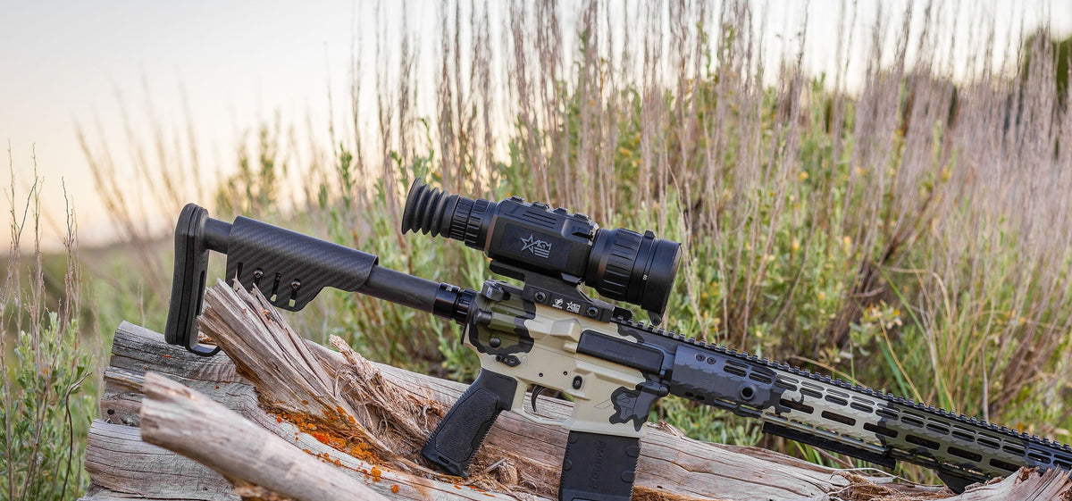 AGM thermal riflescope on a rifle resting on a log